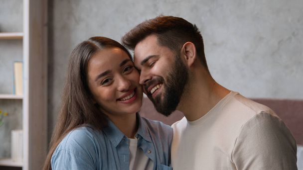 Happy couple in love portrait of Caucasian family married wife and husband newlyweds affectionate cuddling looking at camera tender lovely relationship smiling woman girlfriend and man boyfriend faces - Photo, Image