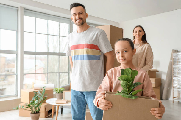 Счастливая семья с картонными коробками в номере в день переезда - Фото, изображение