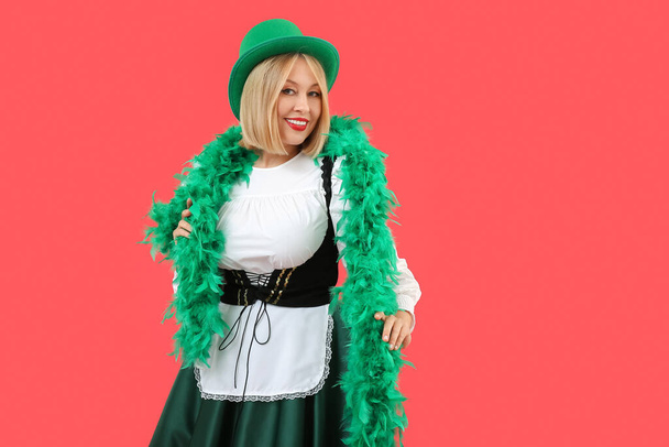 Happy woman in costume for St. Patrick's Day celebration on red background - Photo, Image