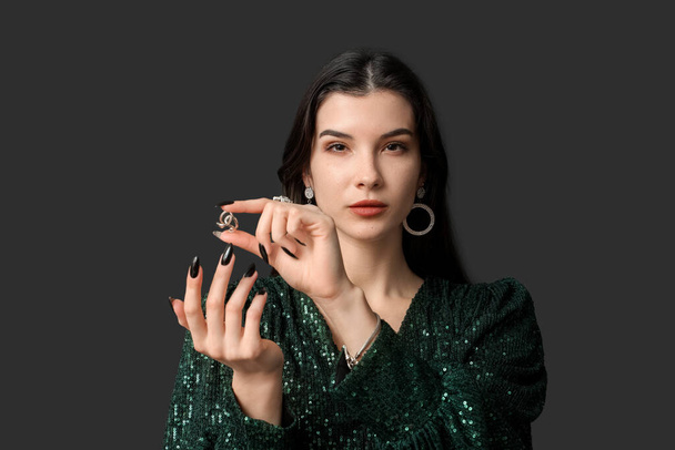 Beautiful young woman with stylish jewelry on black background - Photo, Image