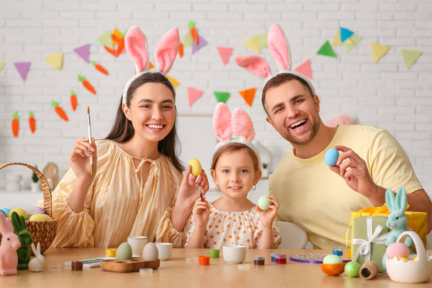 Happy family in bunny ears painting Easter eggs at home - Photo, Image