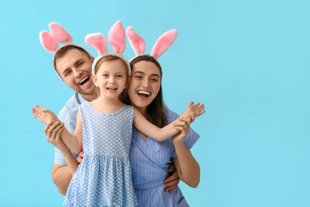 Happy family in Easter bunny ears on blue background - Photo, Image