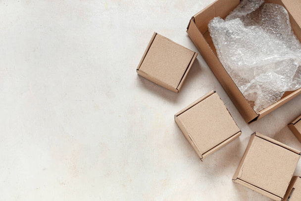 Paquetes de cartón con papel de burbuja sobre mesa blanca - Foto, Imagen