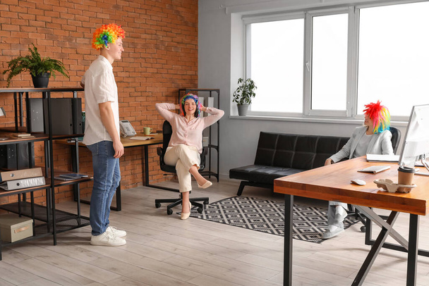 Деловые люди со смешными париками в офисе. Праздник Дня дураков - Фото, изображение