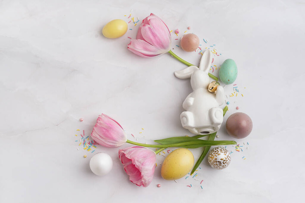 Skład z tulipanami, kolorowe jaja i postać króliczka na jasnym tle - Zdjęcie, obraz