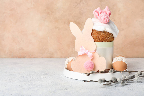 Placa con pastel de Pascua, huevos, conejito de papel y ramas de sauce en la mesa blanca - Foto, Imagen