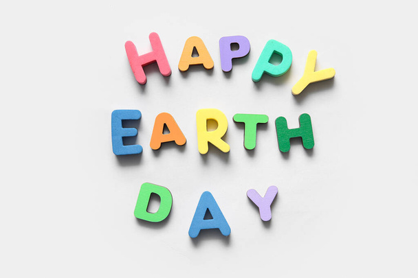 Text HAPPY EARTH DAY auf weißem Hintergrund, Nahaufnahme. Feierlichkeiten zum Tag der Erde. - Foto, Bild