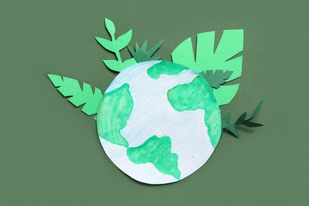 Χάρτινος πλανήτης Γη με πράσινα φύλλα τσόχας σε πράσινο φόντο. Γιορτή της Γης. - Φωτογραφία, εικόνα