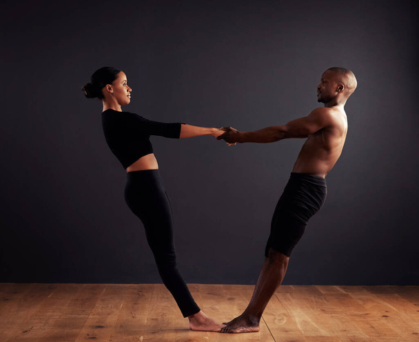 Performance, theatre and duet of people dancing, creative and art of body, moving and passion. Black background, man and woman with pride, confident and ballet with balance in stage or floor. - Photo, Image