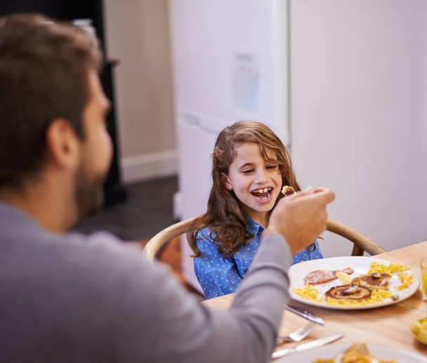 Тато, дитина і сміються вранці зі сніданком для повсякденного життя, щастя і харчування. Батько, дівчина і разом за зв'язок з їжею, годування і домашнє з любов'ю до здорового харчування. - Фото, зображення