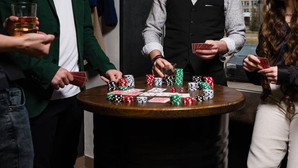 Наблюдение от первого лица за карточным покером с разных сторон крупным планом. Команда молодых мальчиков и девочек играют в покер. - Фото, изображение