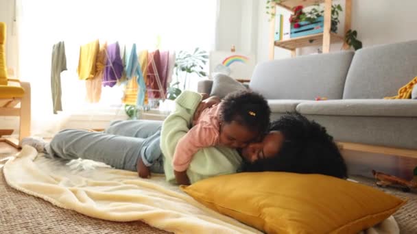 Ein heiterer Moment, als Mutter und Kind ein friedliches Nickerchen gemeinsam auf dem Wohnzimmerboden verbringen. - Filmmaterial, Video