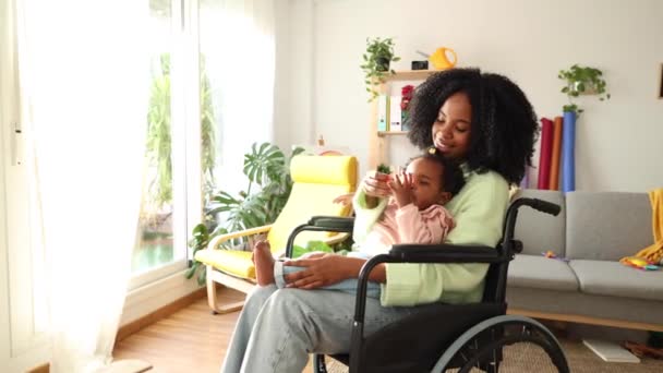 Μια μητέρα σε αναπηρική καρέκλα διαβάζει μια ιστορία στο προσεγμένο παιδί της, που μοιράζεται μια αγάπη για τα βιβλία.. - Πλάνα, βίντεο