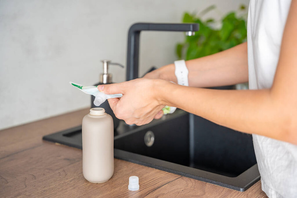 Una donna versa sapone o detersivo da imballaggi riciclati in una bottiglia riutilizzabile. Concetto di stile di vita ecologico. Foto di alta qualità - Foto, immagini