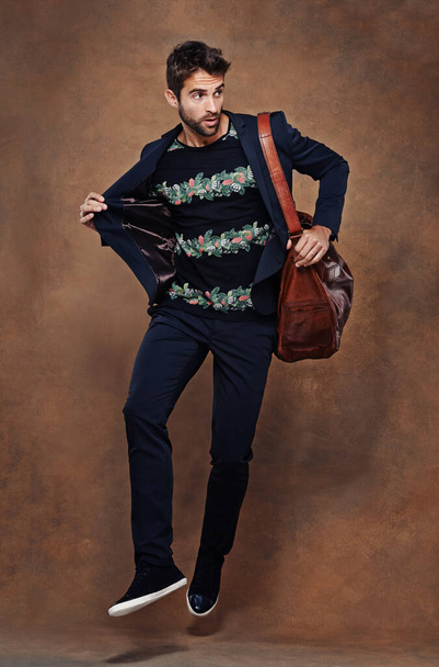 Fashion, jump and pose for male person, studio and business clothing isolated on background. Confidence, stylish and bag for employee or worker man model, professional and formal and trendy outfit. - Photo, Image