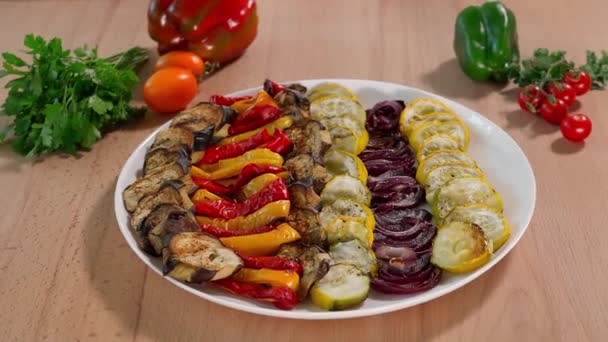 Légumes au four aubergines, poivrons rouges et jaunes, courgettes, oignons, table en bois sur fond de légumes, salade de légumes, plats d'aubergines, nourriture végétarienne, apéritif, gros plan - Séquence, vidéo