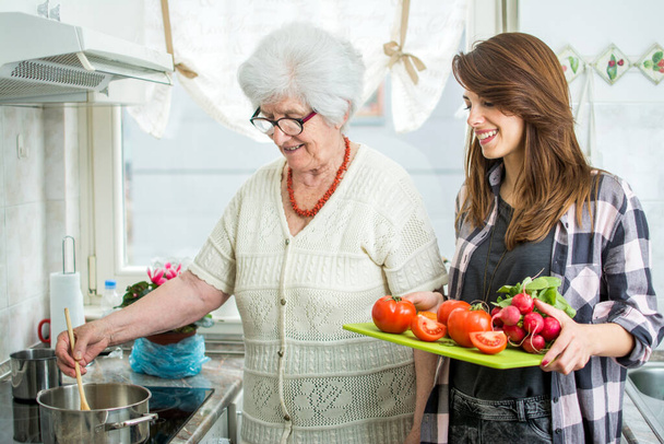 Nonna e nipote cucinano insieme in cucina
 - Foto, immagini