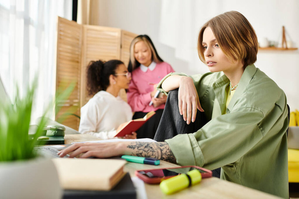 Een vrouw van diverse afkomst zit achter een bureau met een laptop computer, bezig met collaboratieve online studeren met een vriend. - Foto, afbeelding