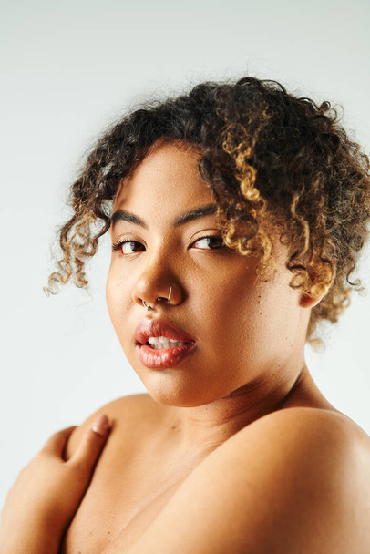 Close-up de mulher afro-americana vibrante com cabelo encaracolado posando com confiança. - Foto, Imagem