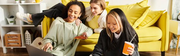 Adolescentes interraciales disfrutando de la amistad en un sofá amarillo mientras están sentadas y charlando en casa. - Foto, imagen