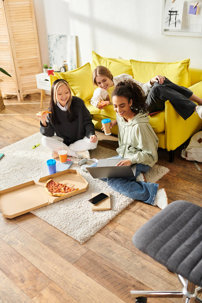 Разнообразная группа девочек-подростков разных национальностей сидит на полу в теплой гостиной, болтая и смеясь. - Фото, изображение