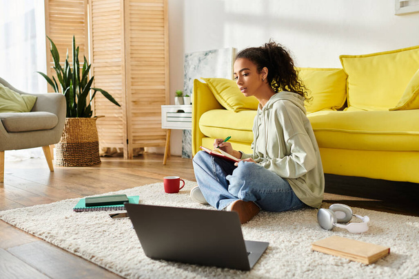 Uma adolescente envolvida em e-learning, sentada no chão com um laptop. - Foto, Imagem
