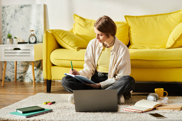 Een tienermeisje zit aandachtig op de vloer voor een laptop, verdiept in haar e-learning reis thuis. - Foto, afbeelding