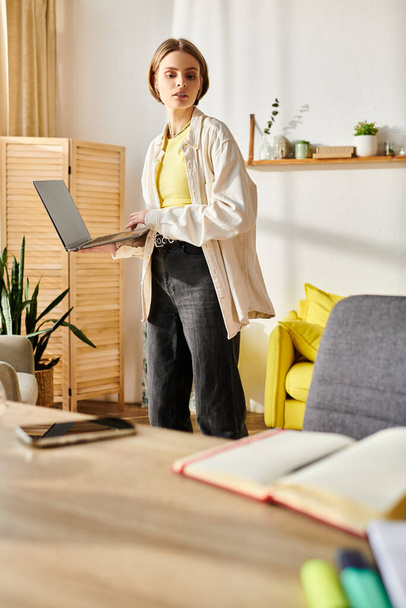 Una adolescente estudia en casa, enfocada en una pantalla de computadora portátil para e-learning. - Foto, imagen