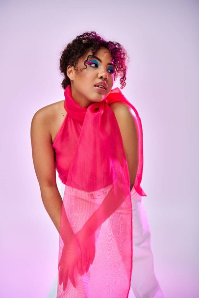 Афроамериканка изящно позирует в розовом платье и шарфе. - Фото, изображение