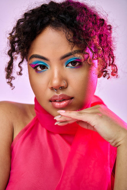 Afro-Amerikaanse vrouw straalt schoonheid in roze top en blauwe oogschaduw tegen een levendige achtergrond. - Foto, afbeelding