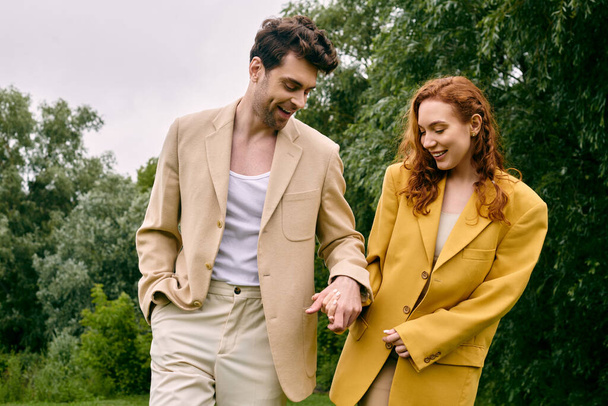 Ein Mann und eine Frau spazieren gemeinsam in einem ruhigen grünen Park und genießen ein romantisches Date in einer üppigen natürlichen Umgebung. - Foto, Bild