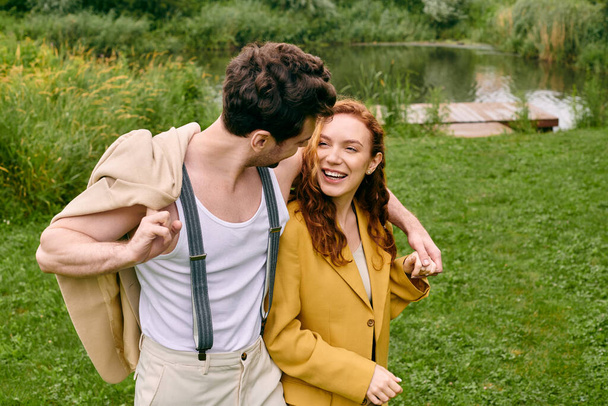 Een man en een vrouw staan zij aan zij in een groen park, genietend van een romantische date in een natuurlijke omgeving. - Foto, afbeelding