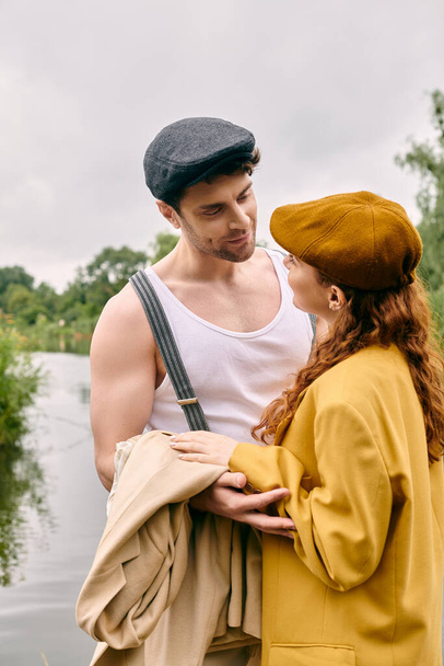 Mężczyzna i kobieta stoją obok siebie w zielonym parku, dzieląc romantyczny moment pośród spokojnej przyrody. - Zdjęcie, obraz