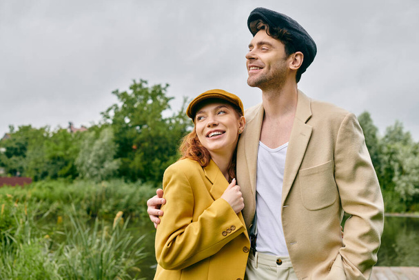 Ein Mann und eine Frau, ein schönes Paar, stehen dicht an dicht in einem üppig grünen Park und genießen ein romantisches Date. - Foto, Bild