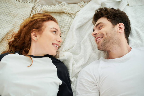 Mężczyzna i kobieta leżący razem w łóżku, cieszący się spokojną chwilą wspólnoty. - Zdjęcie, obraz