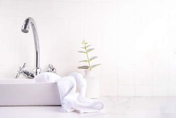 Badezimmerhintergrund mit Waschbecken und Wasserhahn, mit textilem Waschlappen. Weiße einfache leere Badezimmerhintergrund, Attrappe für Ihre Produkte oder Text - Foto, Bild
