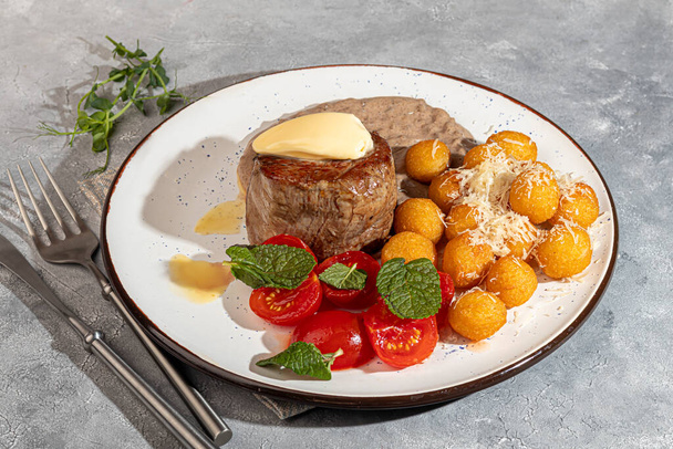 Rindermedaillon mit Kartoffelbällchen und Pilzsoße, garniert mit einem Stück Butter. Kopierraum - Foto, Bild