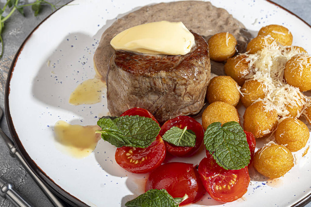 Médaillon de boeuf avec boulettes de pommes de terre et sauce aux champignons, garni d'un morceau de beurre. Espace de copie - Photo, image