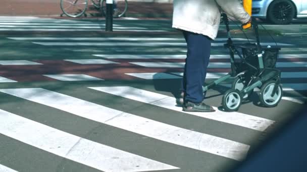 un viejo desconocido cruzando la calle con su marco de caminar, ancianos al aire libre. Imágenes de alta calidad 4k - Metraje, vídeo