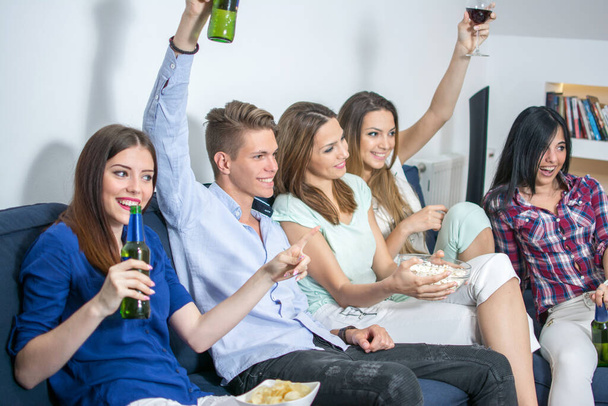 Група молодих друзів, які дивляться телевізійний матч і вітають - Фото, зображення