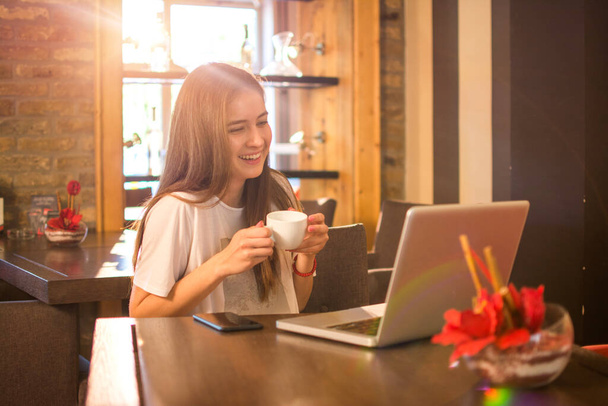 Retrato de una adolescente tomando una bebida caliente en un café - Foto, imagen