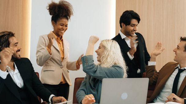Разнообразная группа офисных работников и сотрудников поднимает руки с радостным и радостным праздником за хорошую командную работу и позитивное отношение способствуют успеху бизнеса на украшенном рабочем месте - Фото, изображение