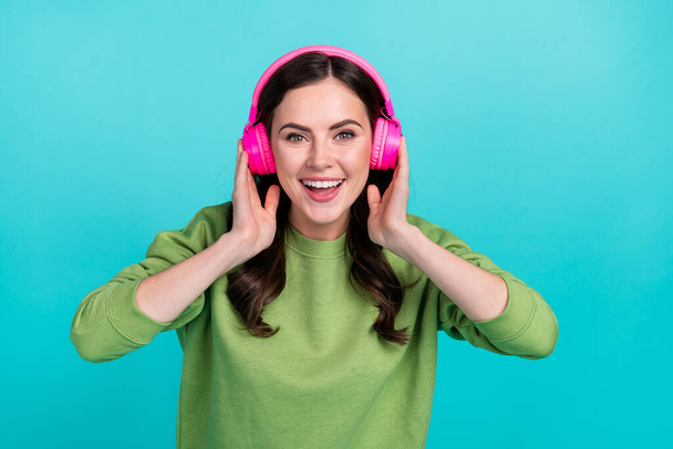 Portrait of positive funky lady beaming smile hands touch headphones isolated on teal color background. - Photo, Image