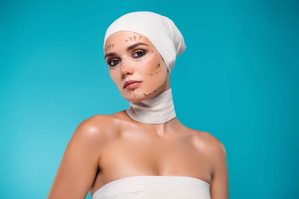 Foto di attraente signora in benda medica hanno chirurgia medicina estetica su sfondo di colore ciano. - Foto, immagini