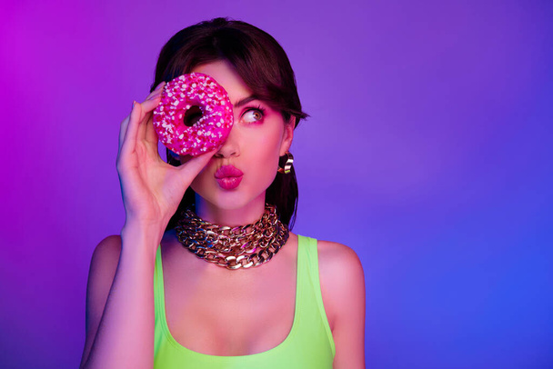 photo of girl with pouted lips cover face tasty cookie look empty space isolated colorful neon background. - Photo, Image