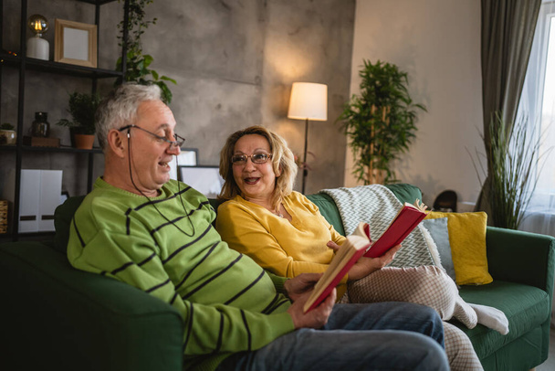 Dojrzałe seniorzy mężczyzna i kobieta mąż i żona czytać książki w domu - Zdjęcie, obraz