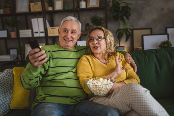 カップル慎重な男と女性はソファーベッドで自宅に座ってテレビ映画を見る - 写真・画像