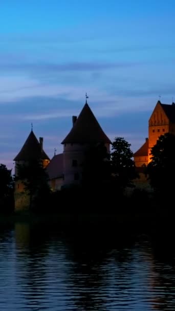 Castelo da Ilha de Trakai no lago Galve iluminado à noite refletindo em águas tranquilas, Lituânia - Filmagem, Vídeo