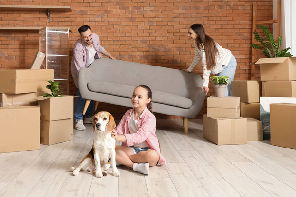 Щаслива сім'я з собакою, що носить диван в кімнаті в рухомий день - Фото, зображення