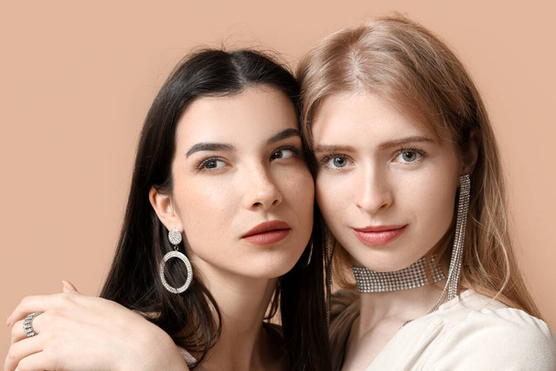 Jovens mulheres bonitas com jóias elegantes no fundo marrom - Foto, Imagem